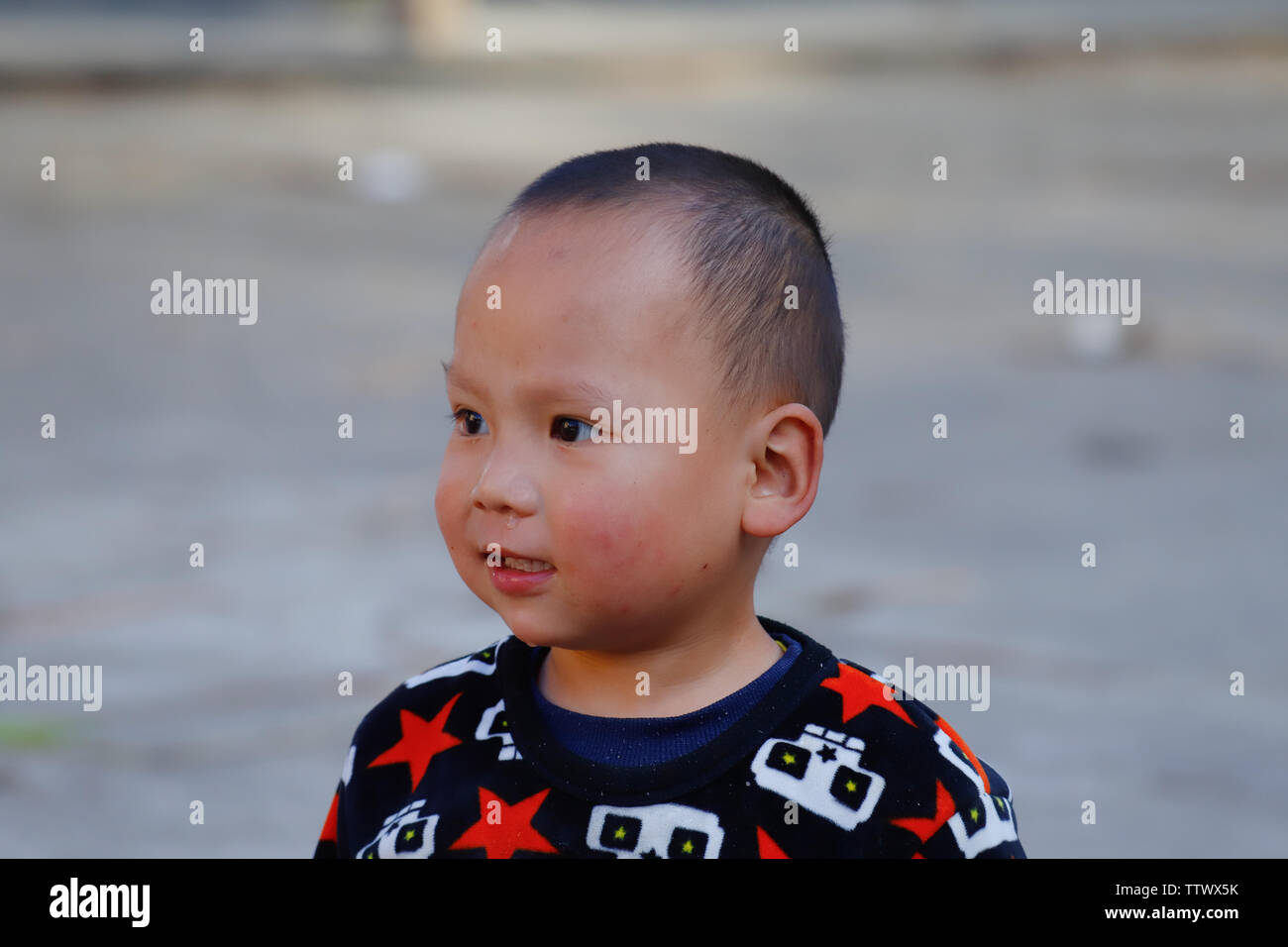 A young child in a village near the rice fields of Yunnan, China. The famous terraced rice fields of Yuanyang in Yunnan province in China. Yunnan, Chi Stock Photo
