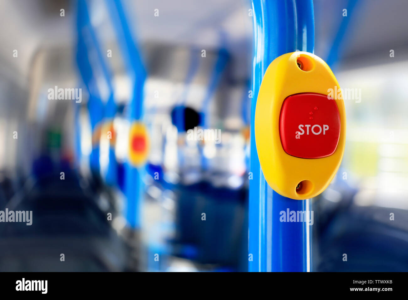 Stop button on a colorful modern city bus close up. Blurred background