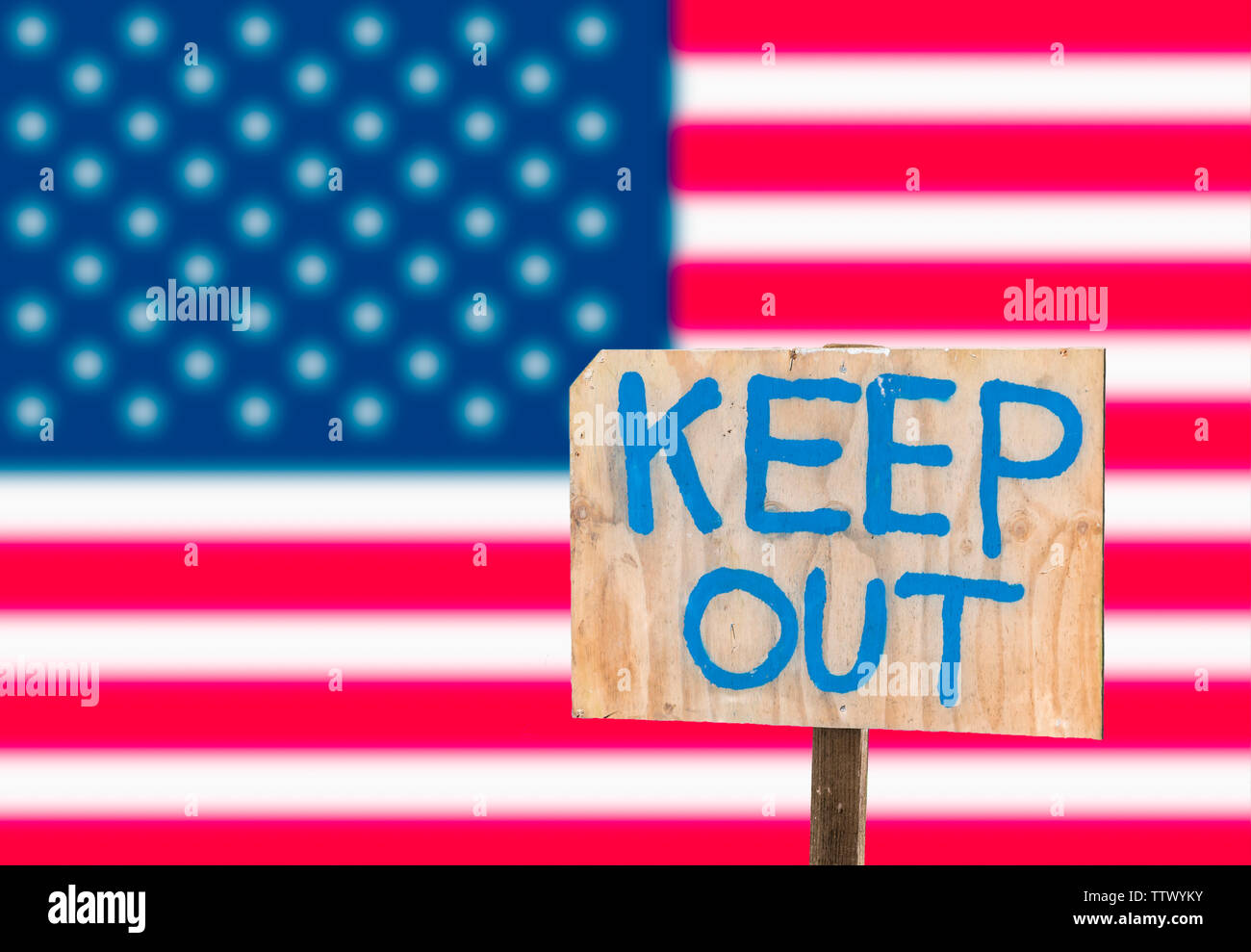 Keep out sign in front of the USA flag, to signify a closed border and the proposed wall between Mexico and the USA. Stock Photo
