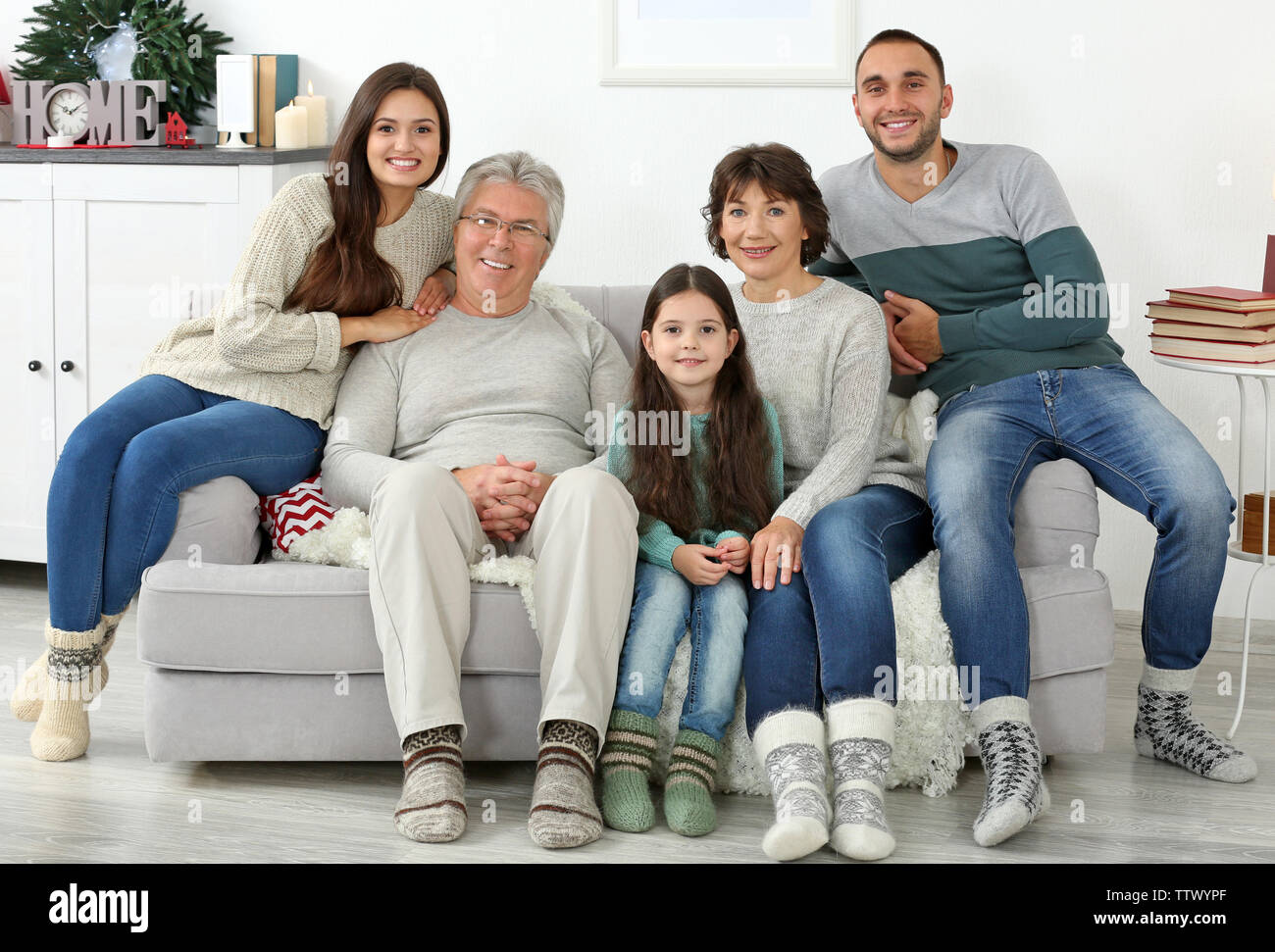 Happy family sitting on sofa in living room Stock Photo - Alamy