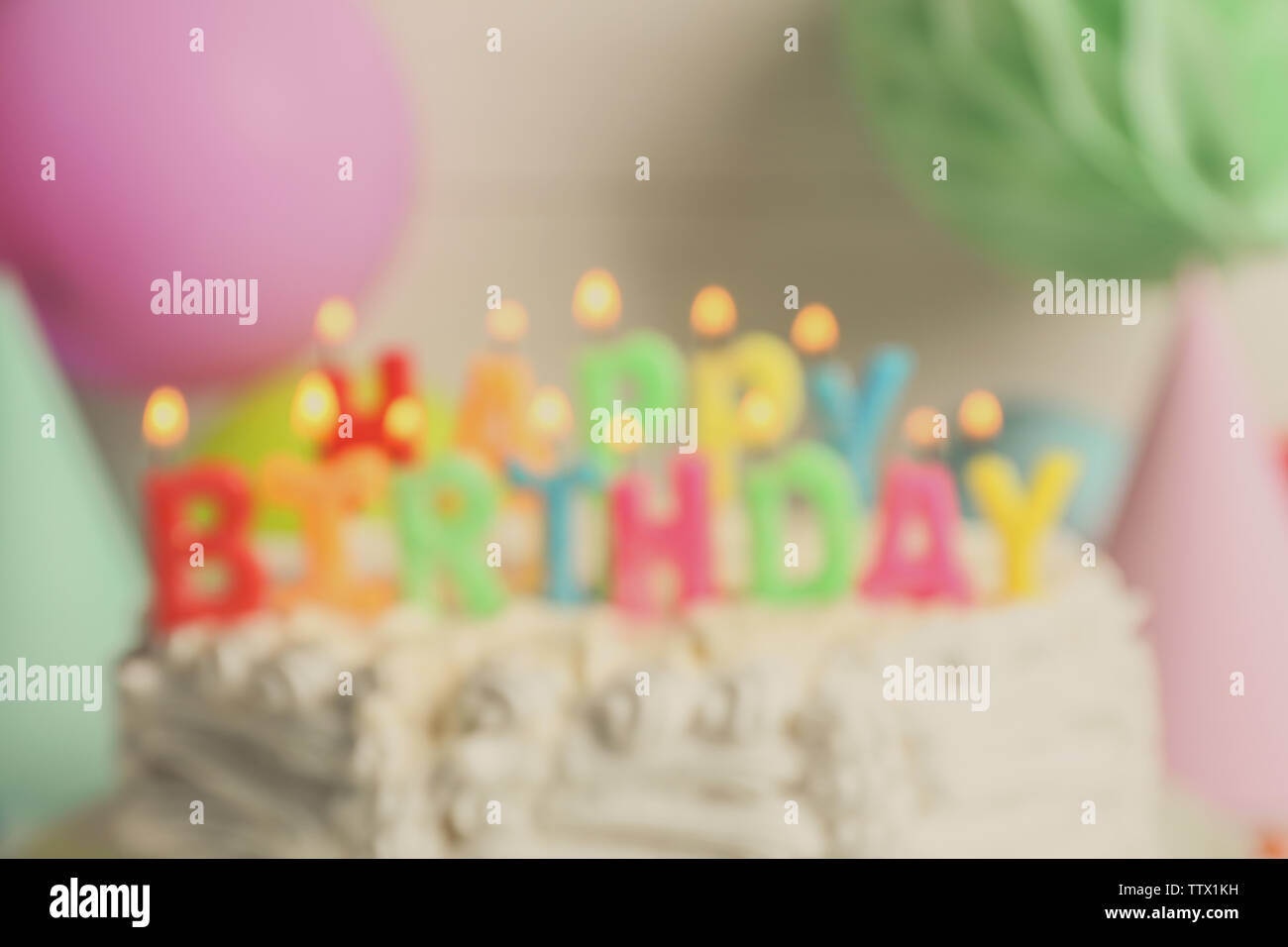 Blurred Birthday cake with candles on light background Stock Photo - Alamy