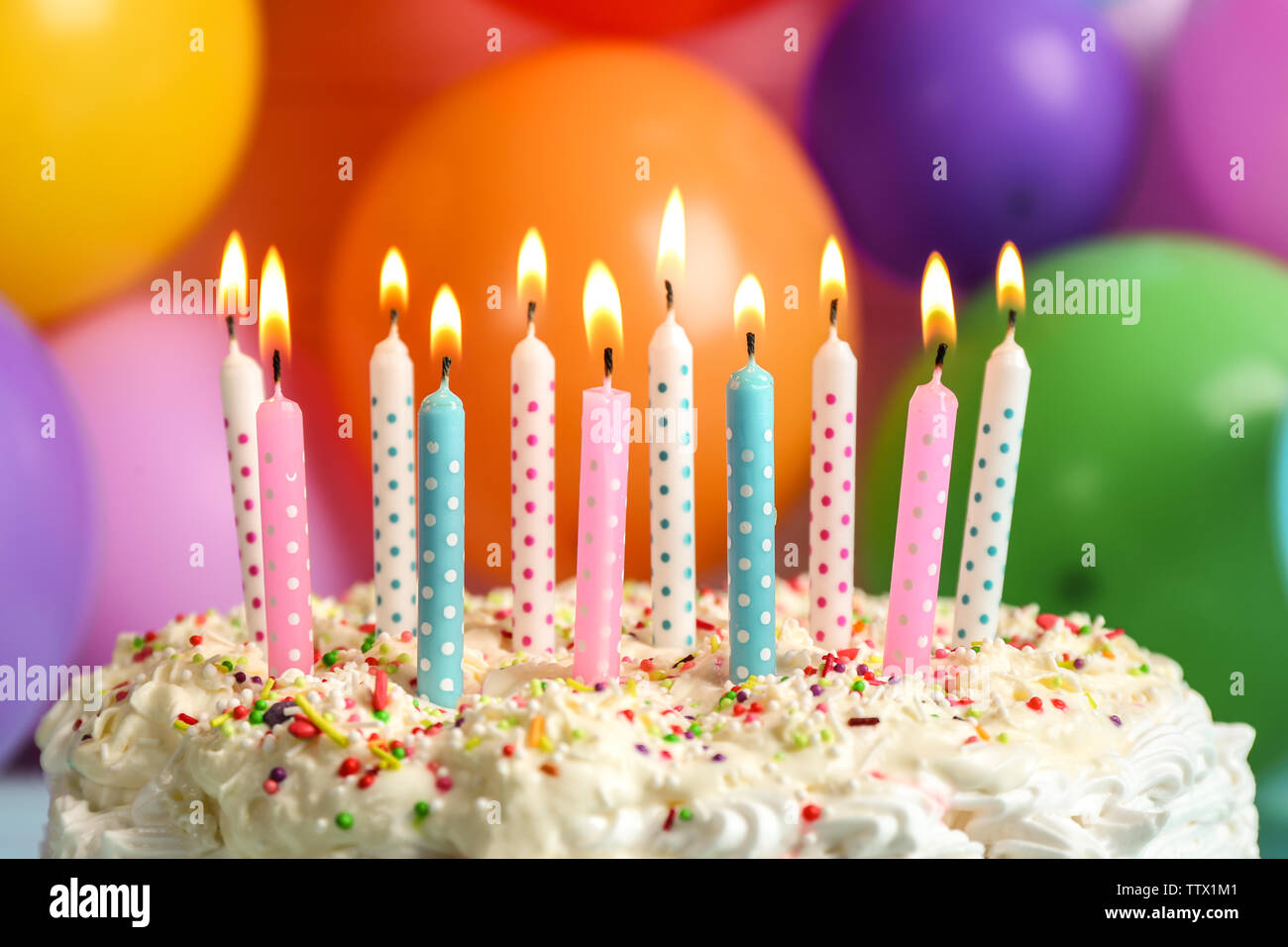 Birthday cake with candles on balloons background Stock Photo - Alamy
