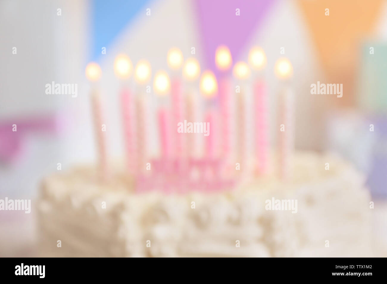 Blurred Birthday cake with candles on light background Stock Photo - Alamy