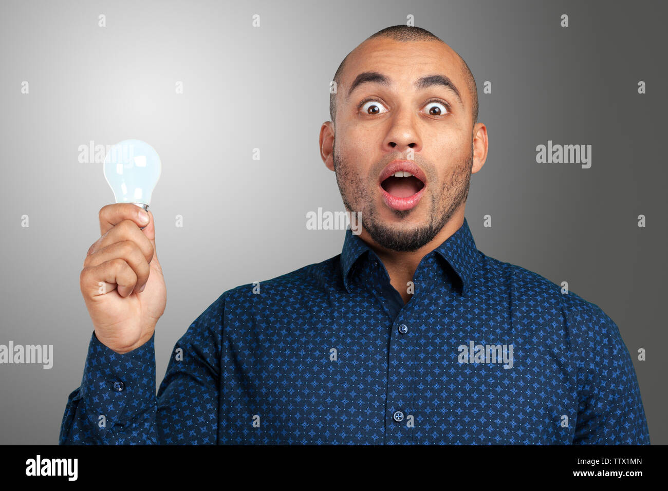 Happy Young Businessman Holding Light Bulb Stock Photo