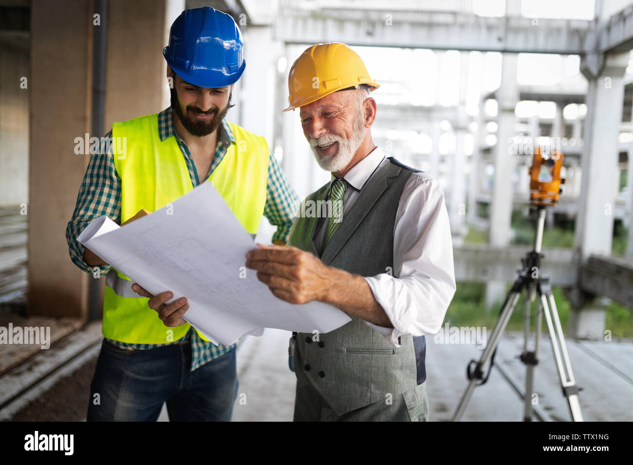 Engineer and construction site manager dealing with blueprints and plans Stock Photo