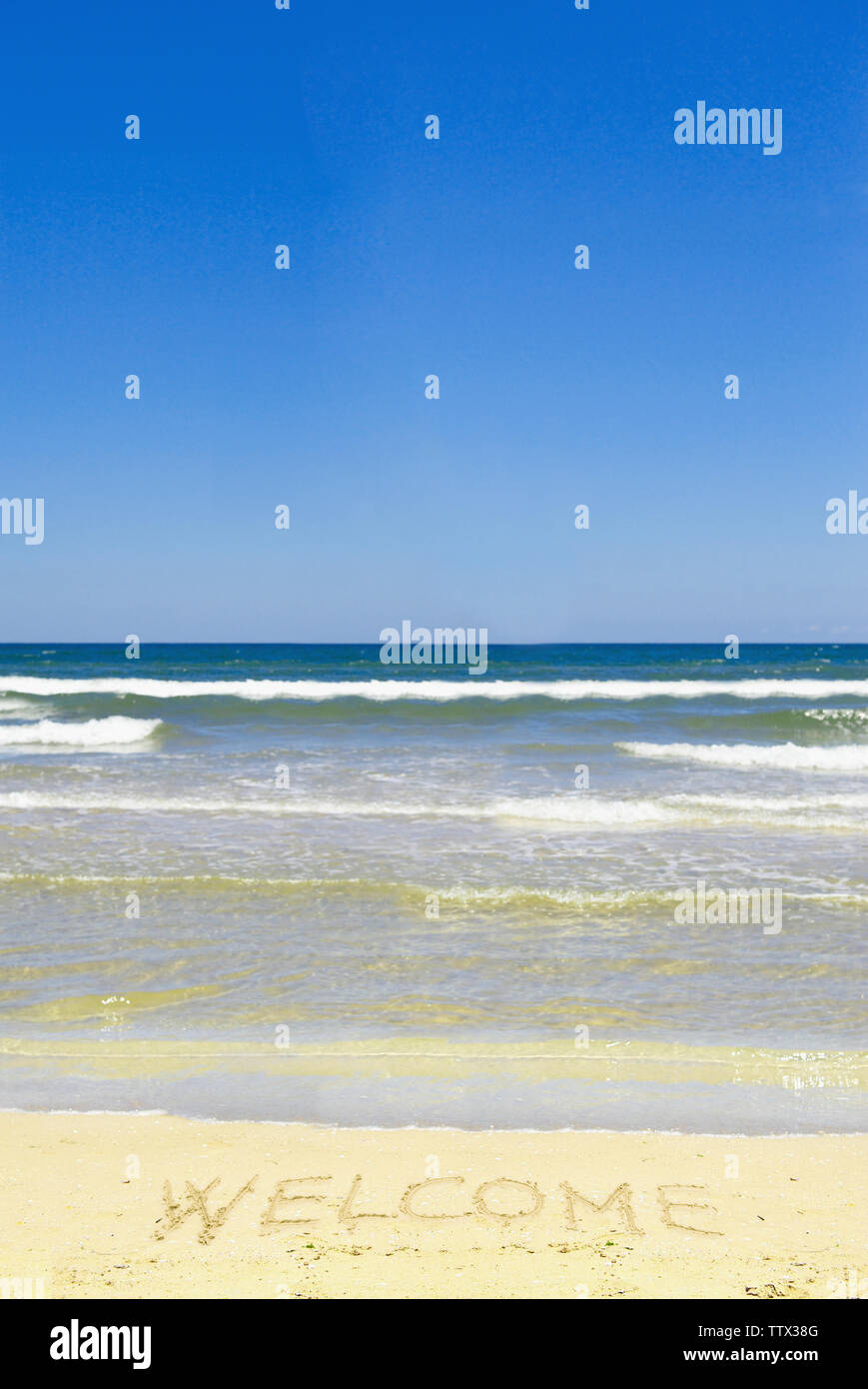 Welcome sign drawn on beach sand Stock Photo - Alamy