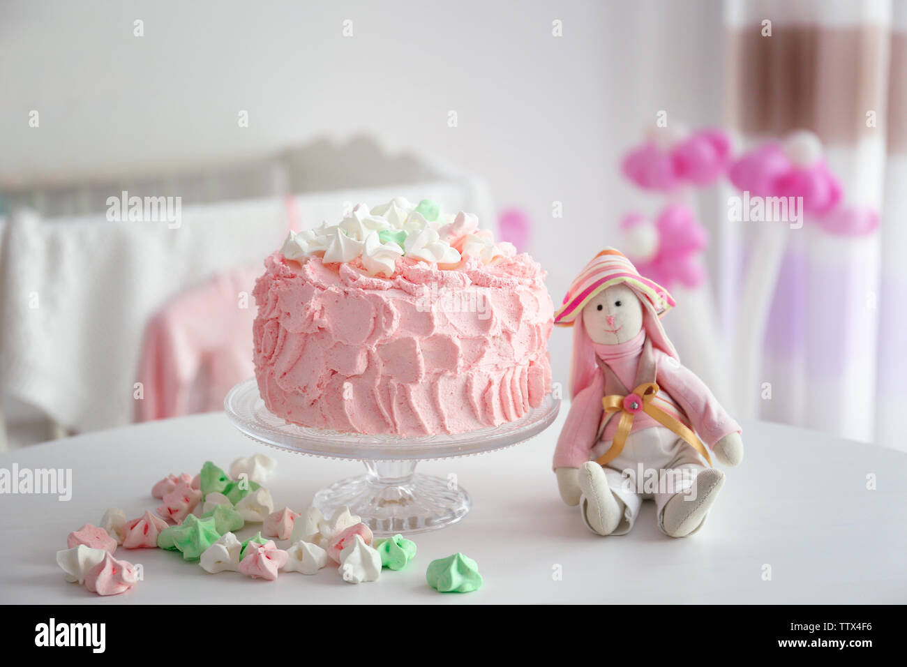 Tasty birthday cake and bunny toy on table in room Stock Photo - Alamy