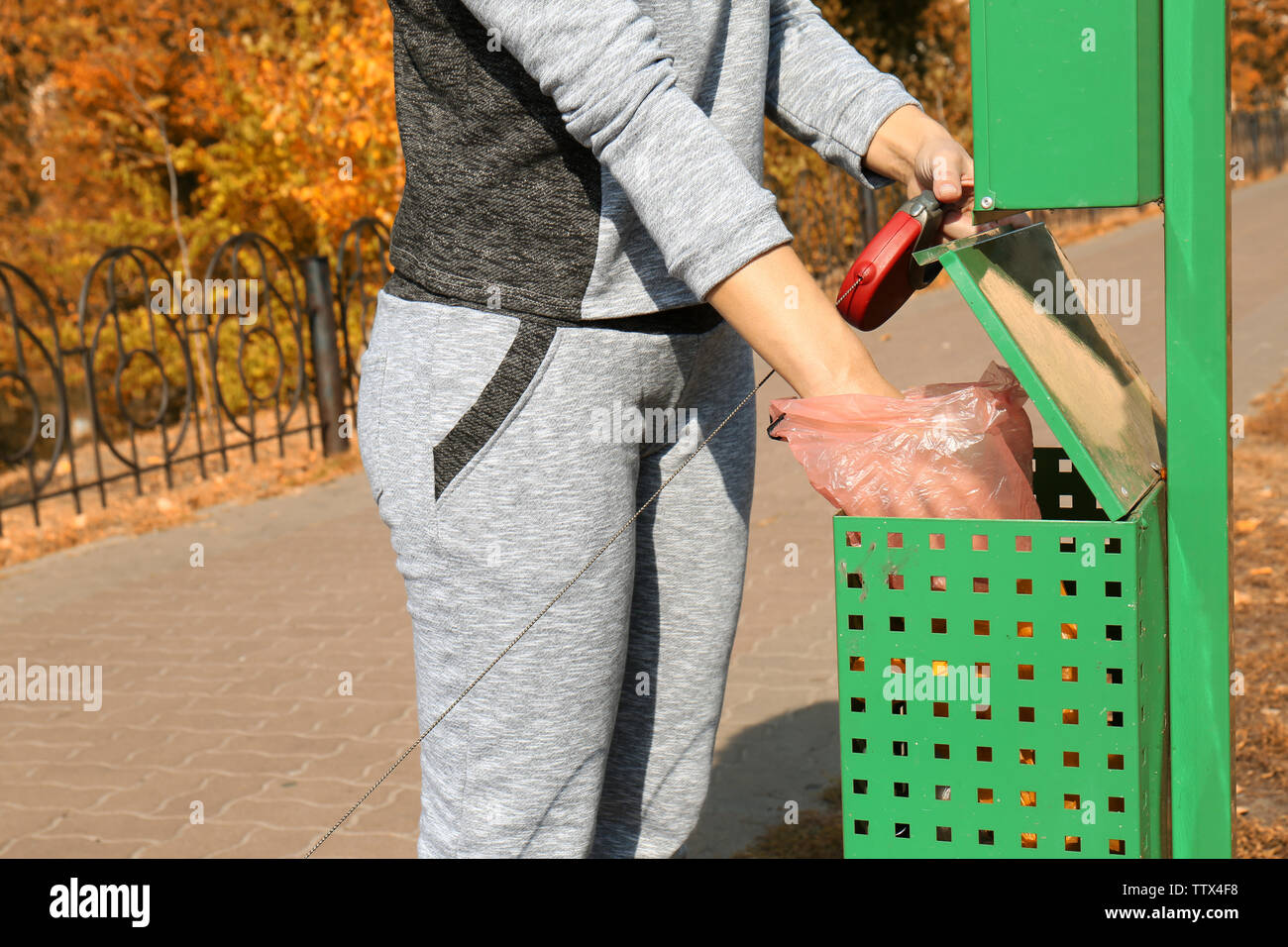 Woman throwing dog poo in container Stock Photo Alamy