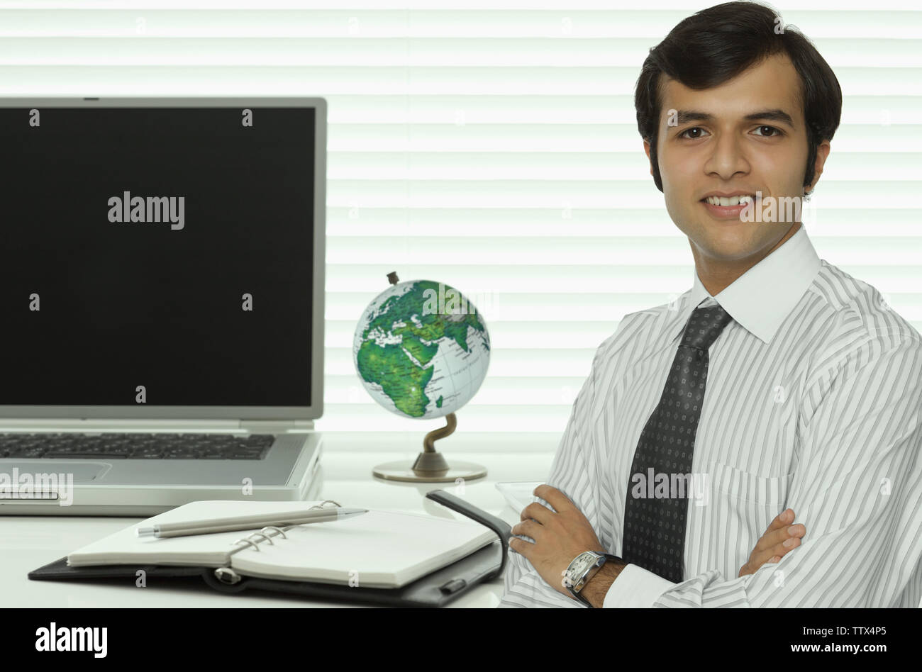 Portrait of a businessman smiling with arms crossed Stock Photo - Alamy