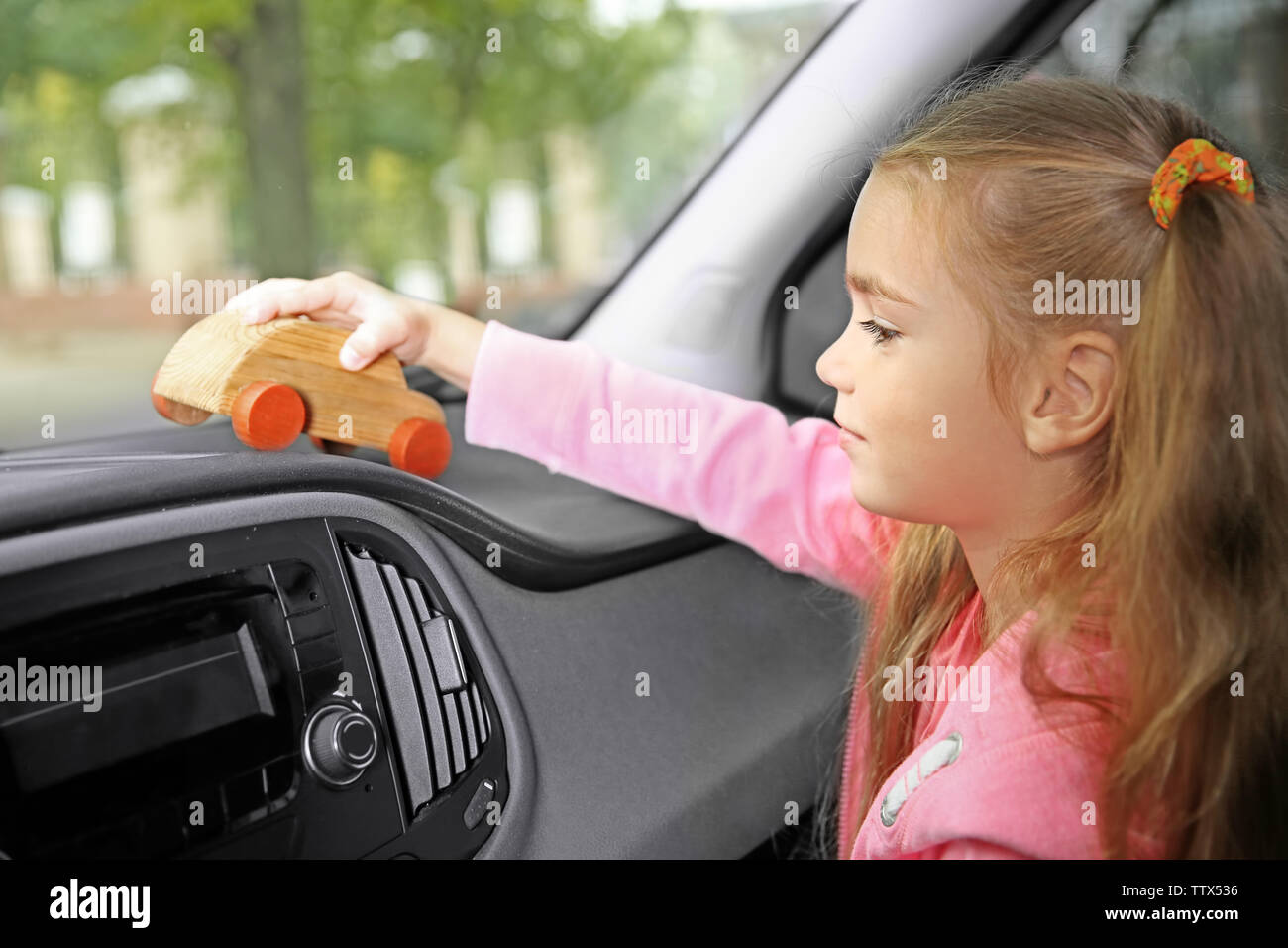 Little girl playing with wooden toy in a car Stock Photo - Alamy