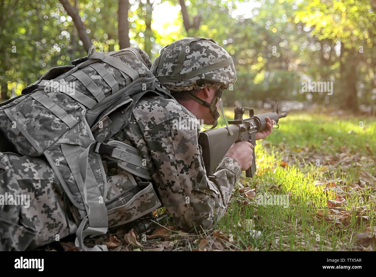 Soldier taking aim from rifle in forest, close up view Stock Photo - Alamy