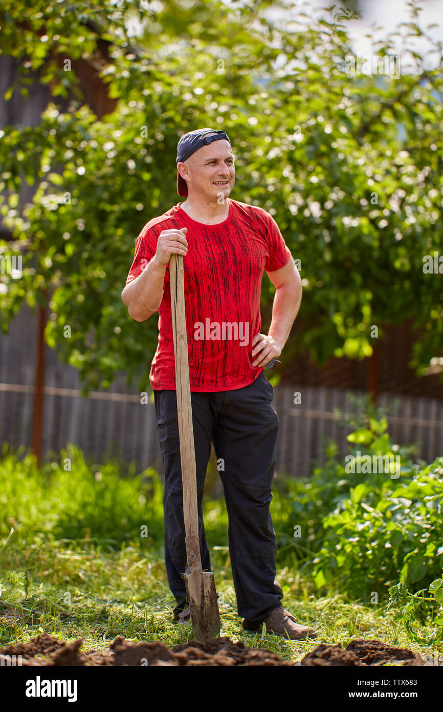 Farmer working with a shovel in his garden Stock Photo - Alamy