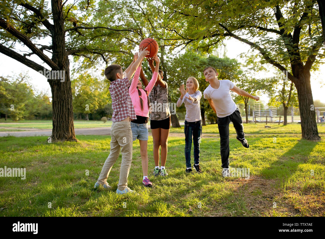Cute kids playing with ball on green grass Stock Photo - Alamy