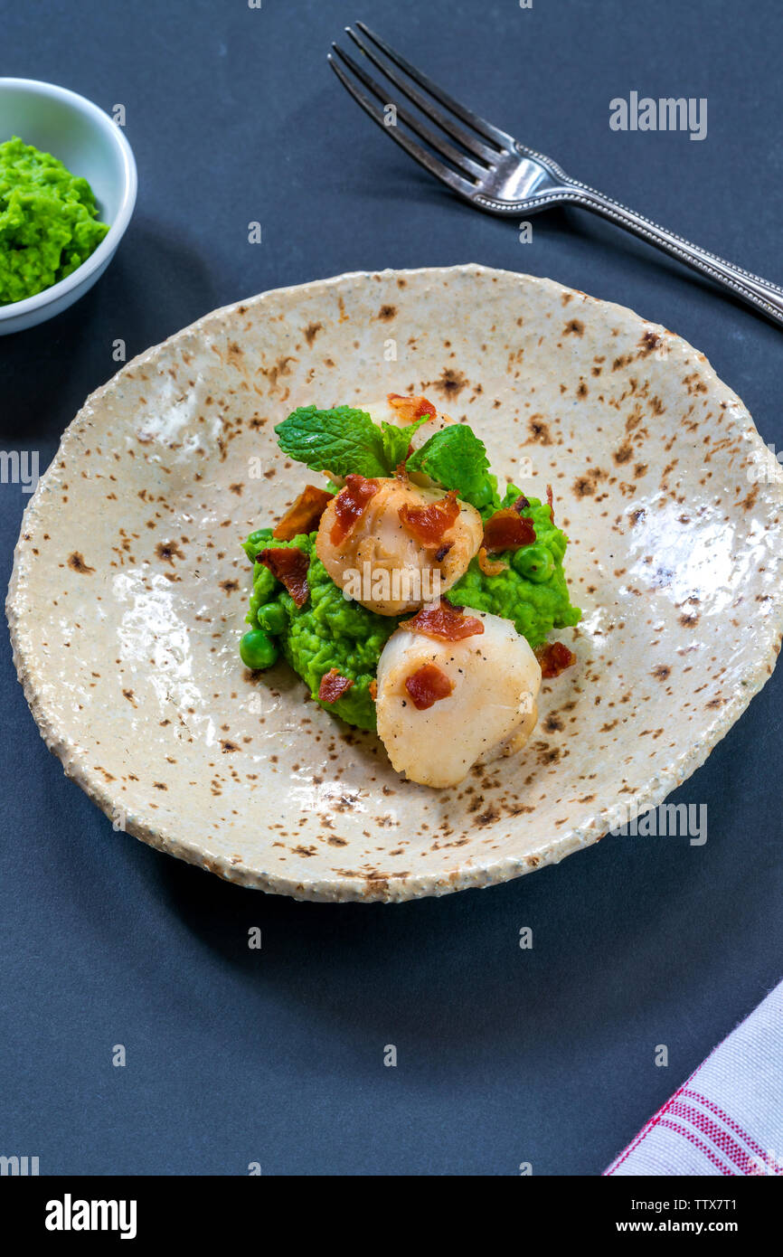 Scallops with minted peas and crispy pancetta high angle view Stock