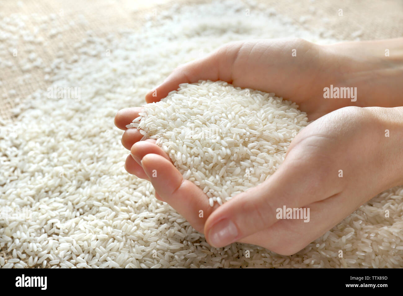 Female hands full of white rice closeup Stock Photo - Alamy
