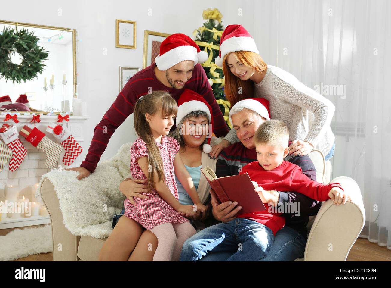 Family in living room decorated for Christmas Stock Photo - Alamy
