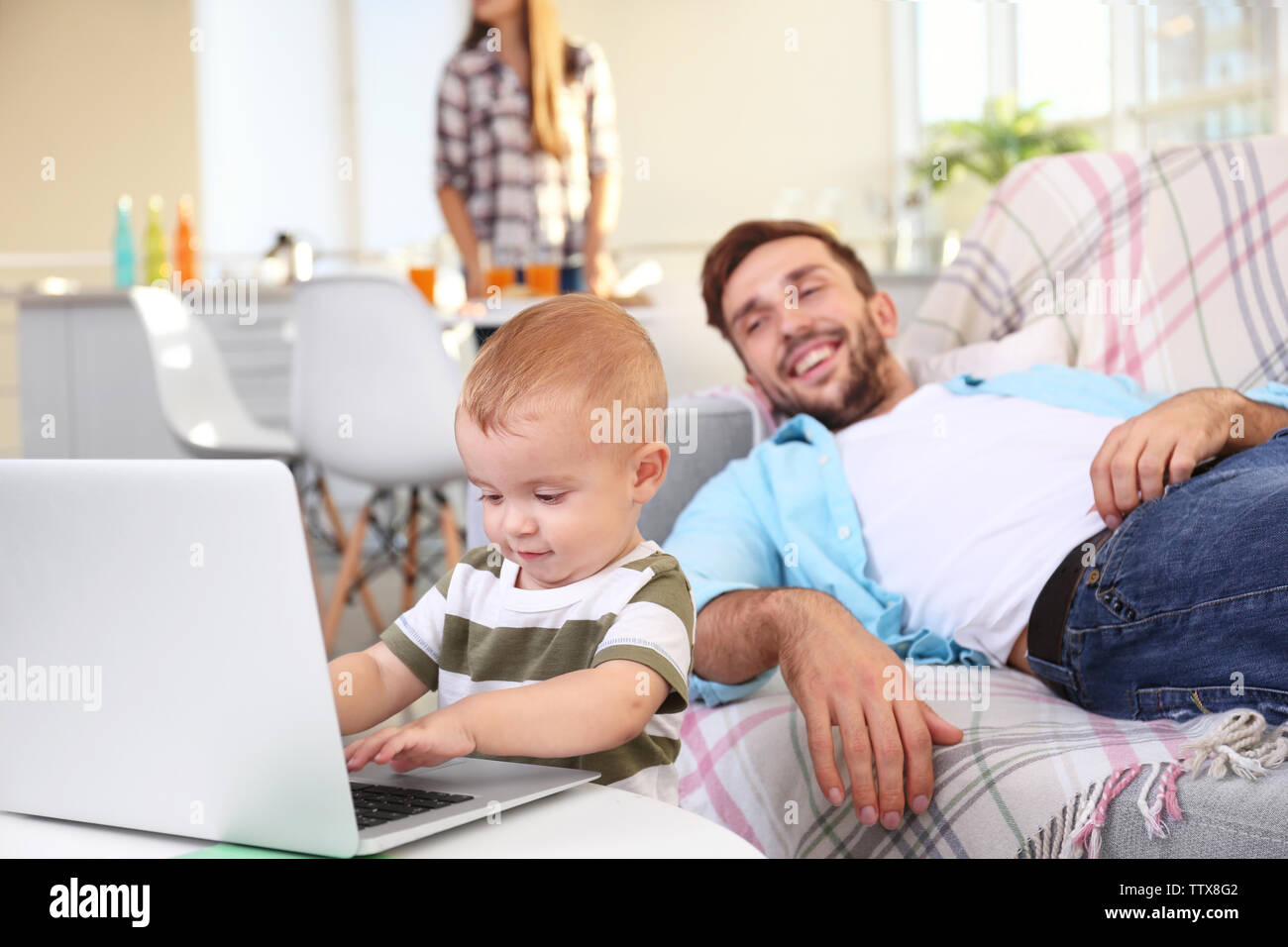 Cute baby boy using laptop under father control Stock Photo - Alamy