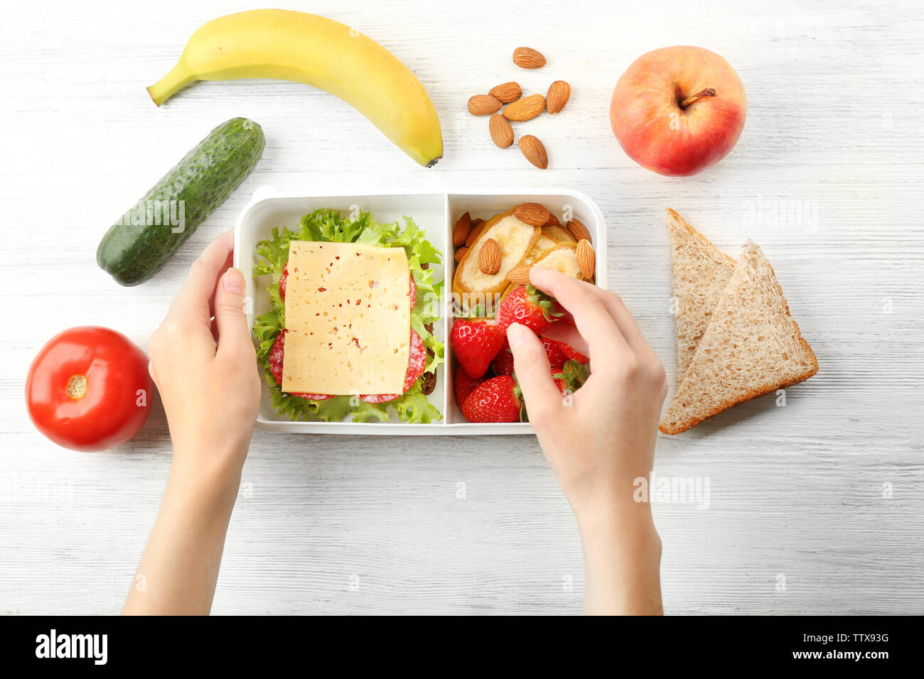 Mother putting food in lunch box, top view Stock Photo Alamy