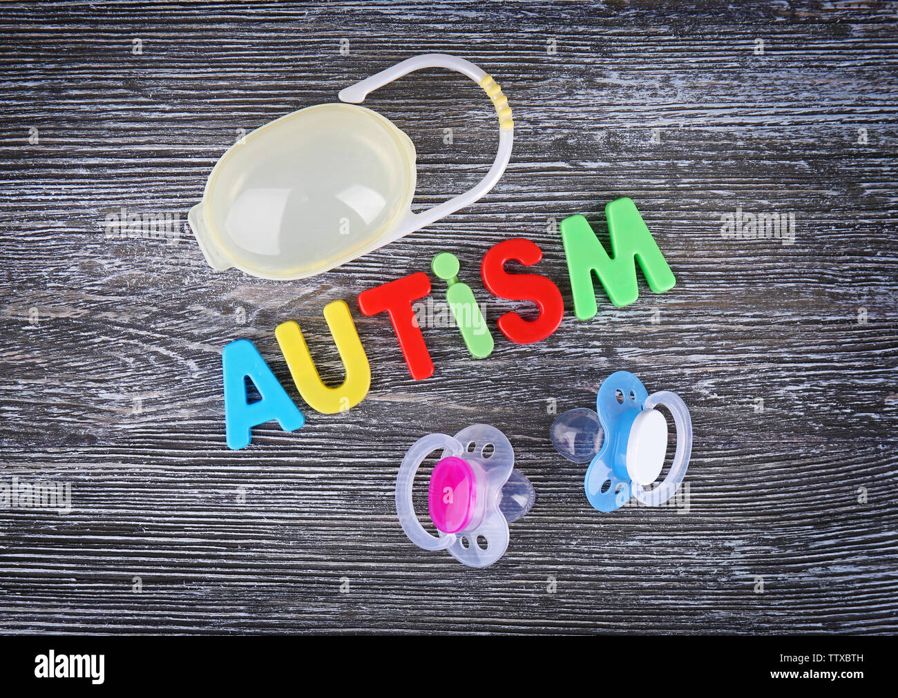 Word Autism with pacifiers on wooden background Stock Photo Alamy
