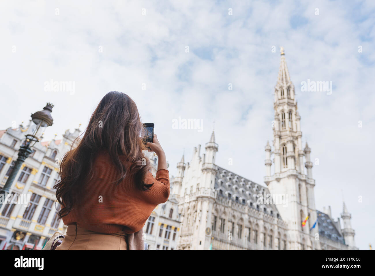 Travelling in Europe, Young woman taking photo by mobile smart phone at grand-palace in Brussels, Belgium in summer Stock Photo