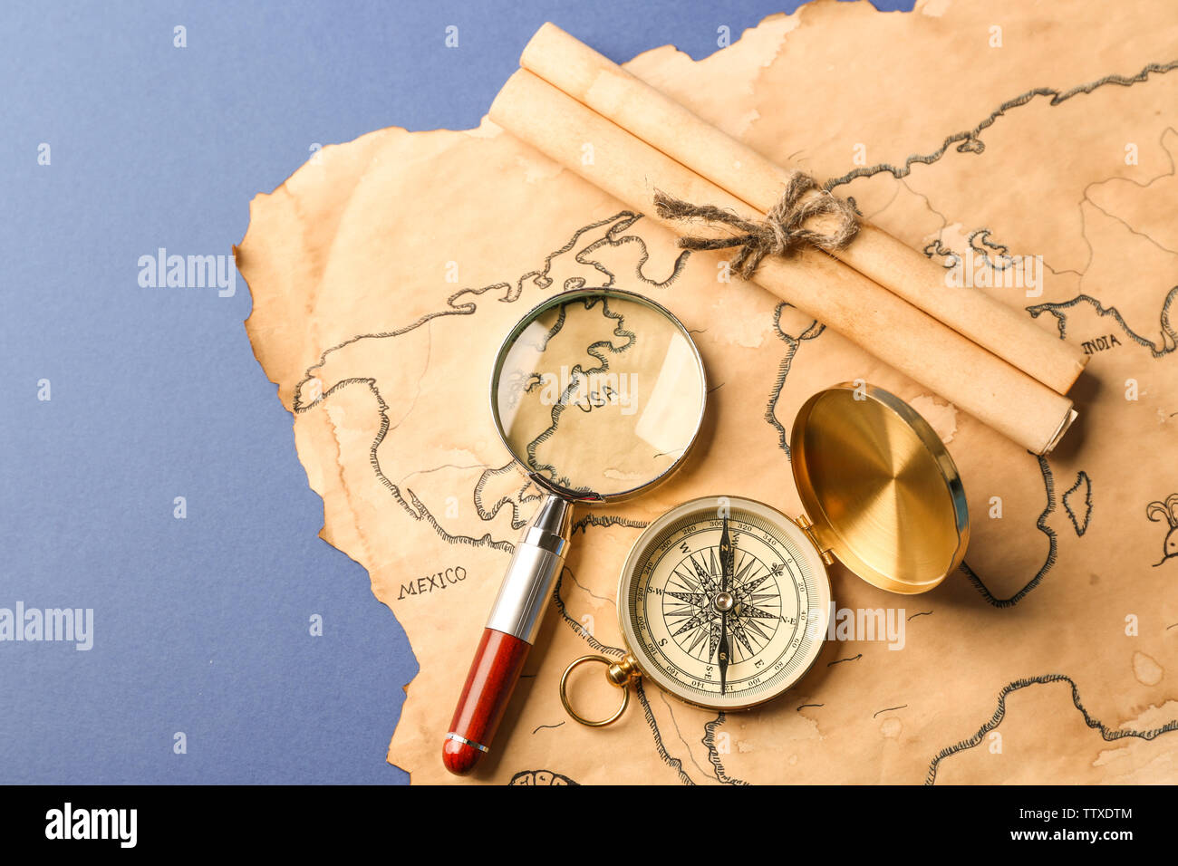 Compass, scroll, magnifier and old map on blue background. Columbus Day ...