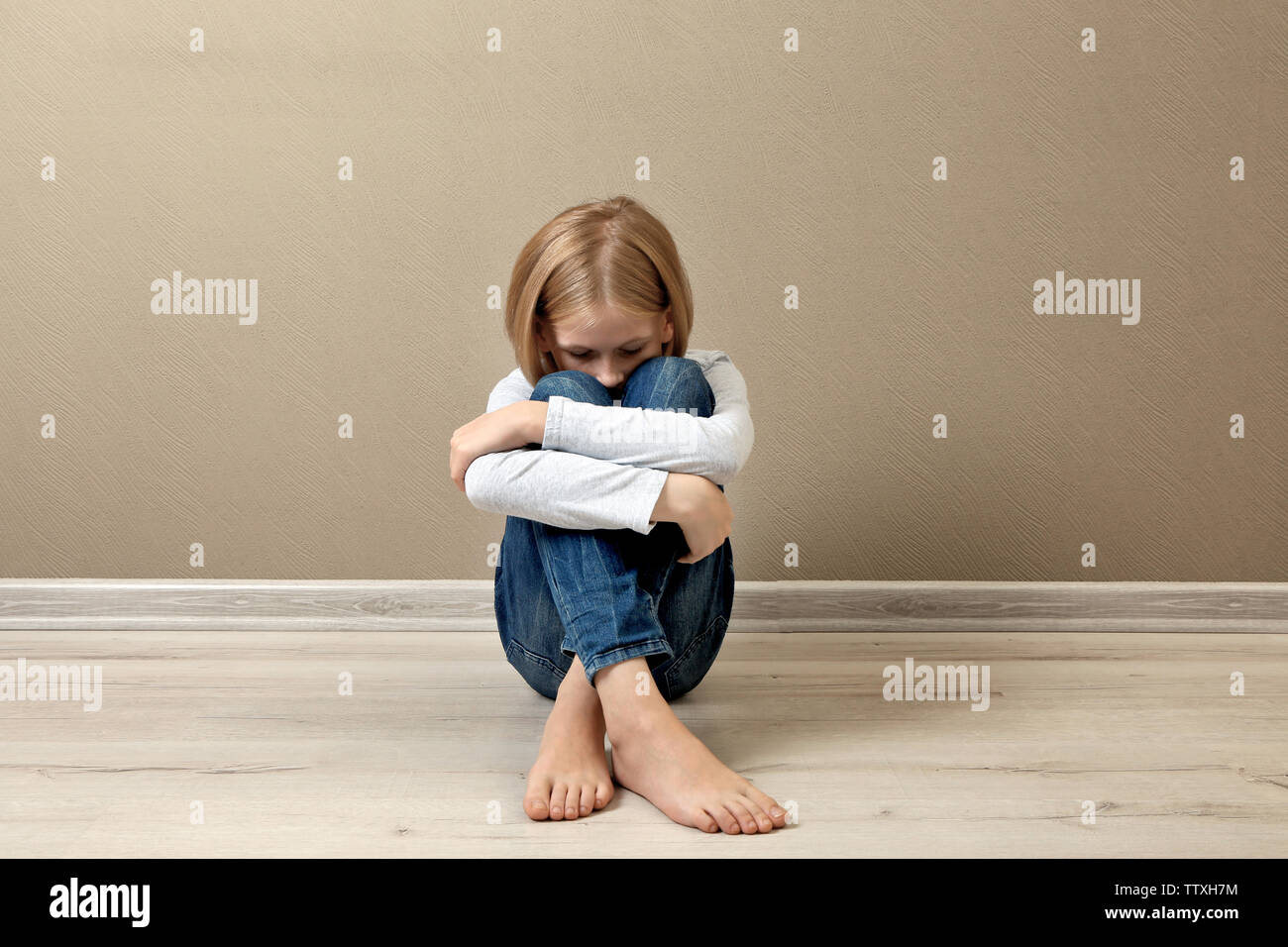 Upset girl sitting on the floor at home Stock Photo - Alamy