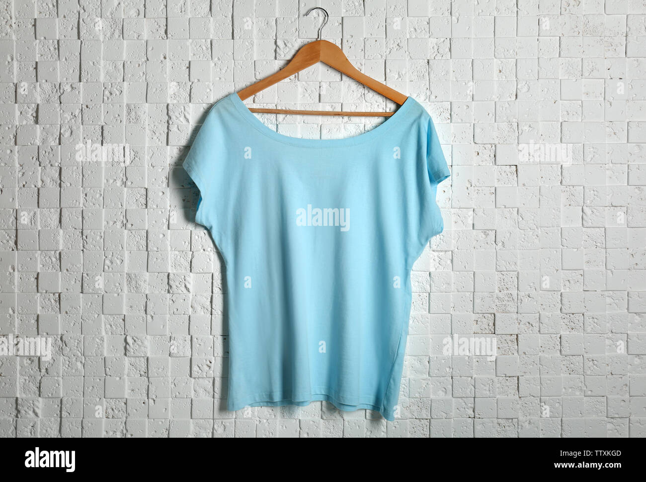 Blank light blue t-shirt against textured background Stock Photo - Alamy