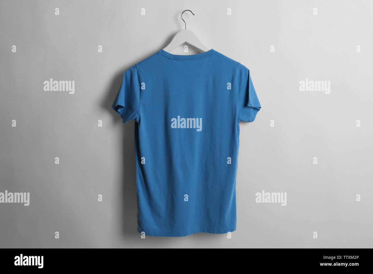 Blank blue t-shirt on light background Stock Photo - Alamy