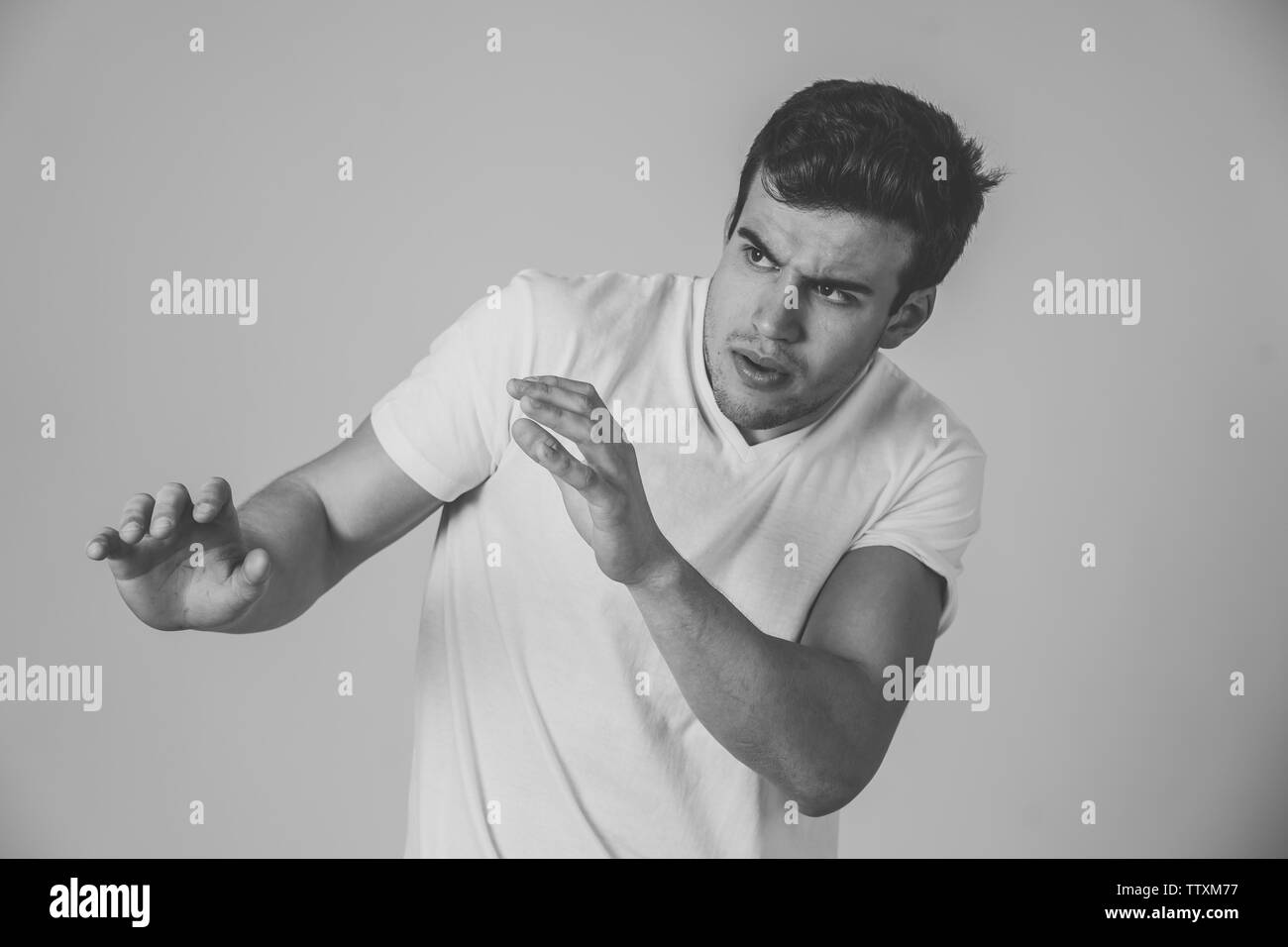 Portrait of Handsome latin young man in shock with a scared expression on his face making frightened and defence gestures in human emotions feelings a Stock Photo