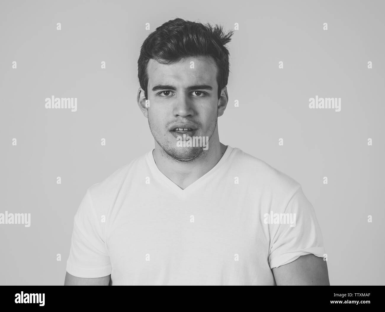 Close up headshot of young latin man with natural and neutral face and masculine look. Isolated on neutral background. In People, fashion, lifestyle B Stock Photo