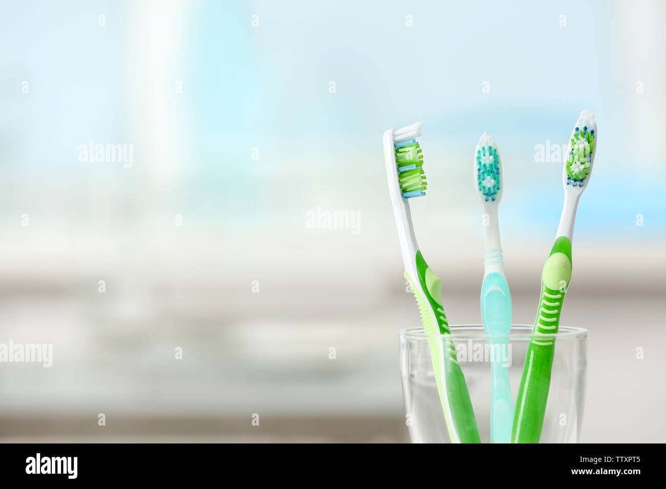 Toothbrushes in glass on blurred background Stock Photo