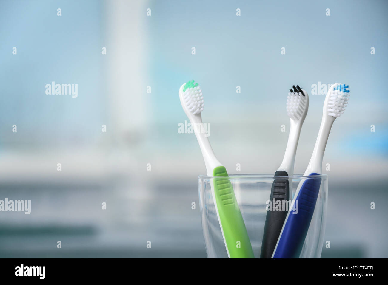 Toothbrushes in glass on blurred background Stock Photo