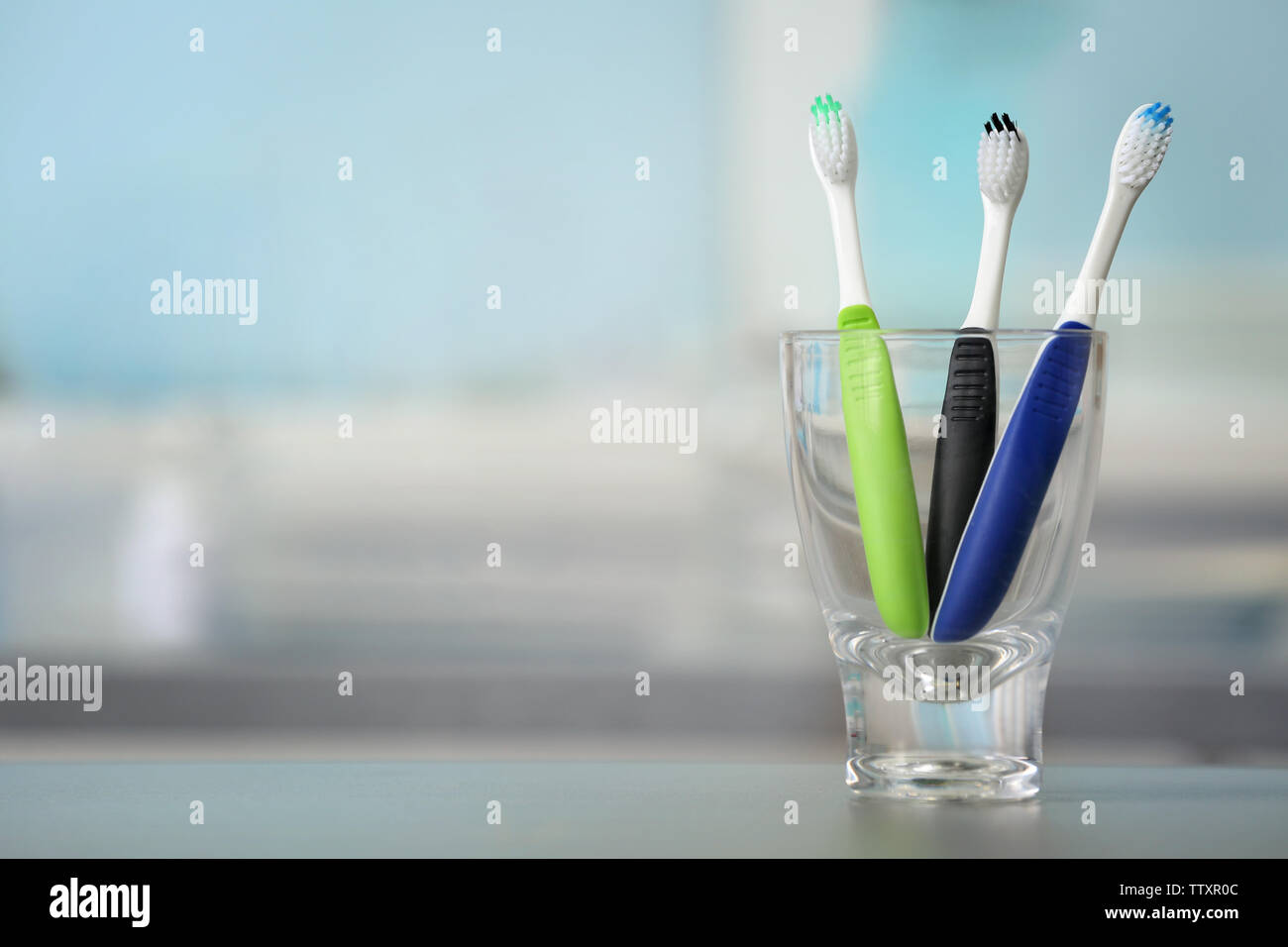 Toothbrushes in glass on blurred background Stock Photo