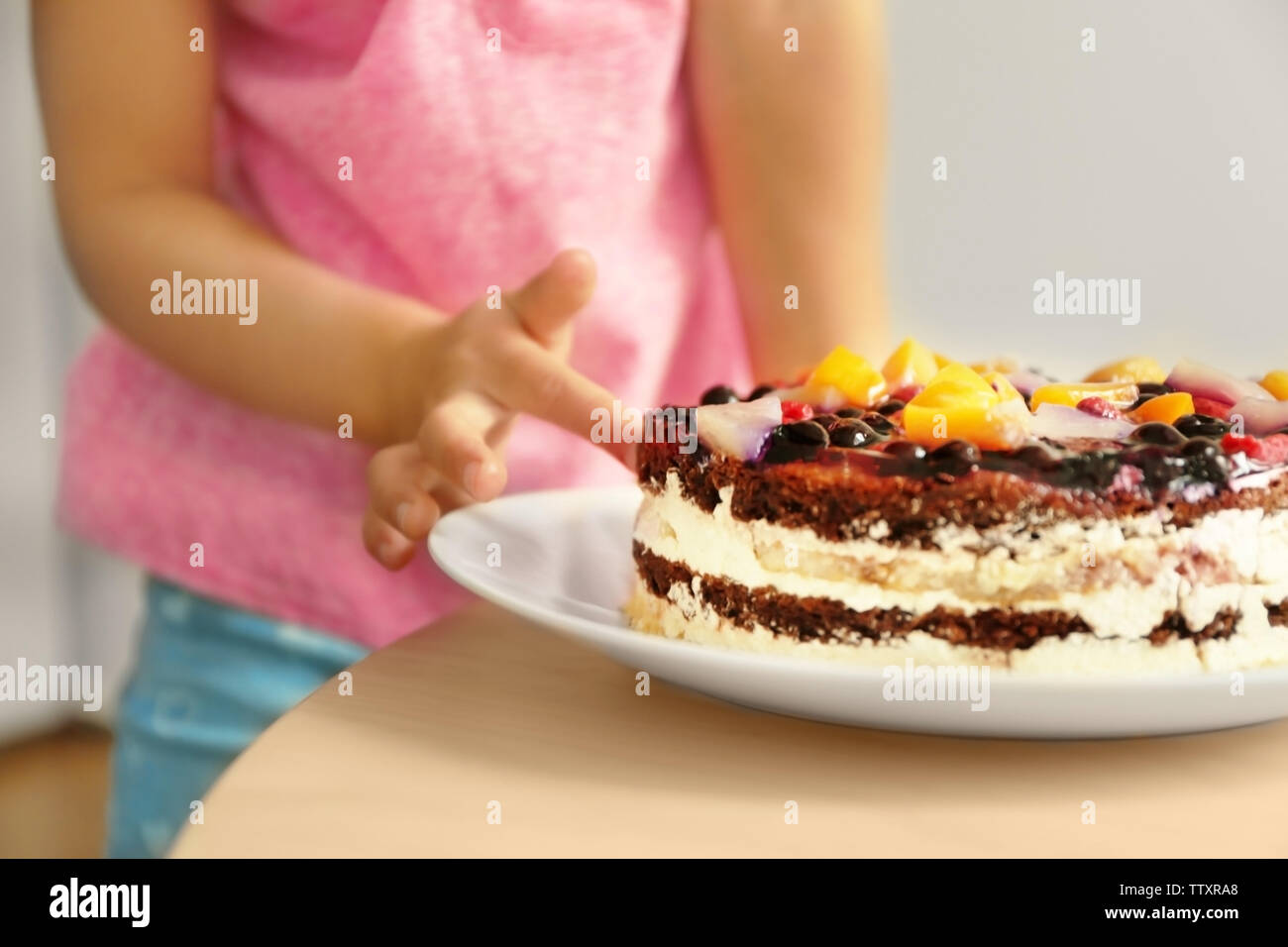 Little Girl Tasting Sweet Cake Left On Kitchen Table Close Up View Stock Photo Alamy