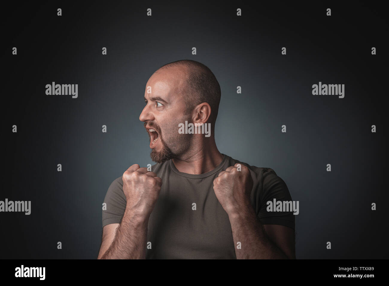 Man posing as a winner and with a head in profile. Studio shot. Concept