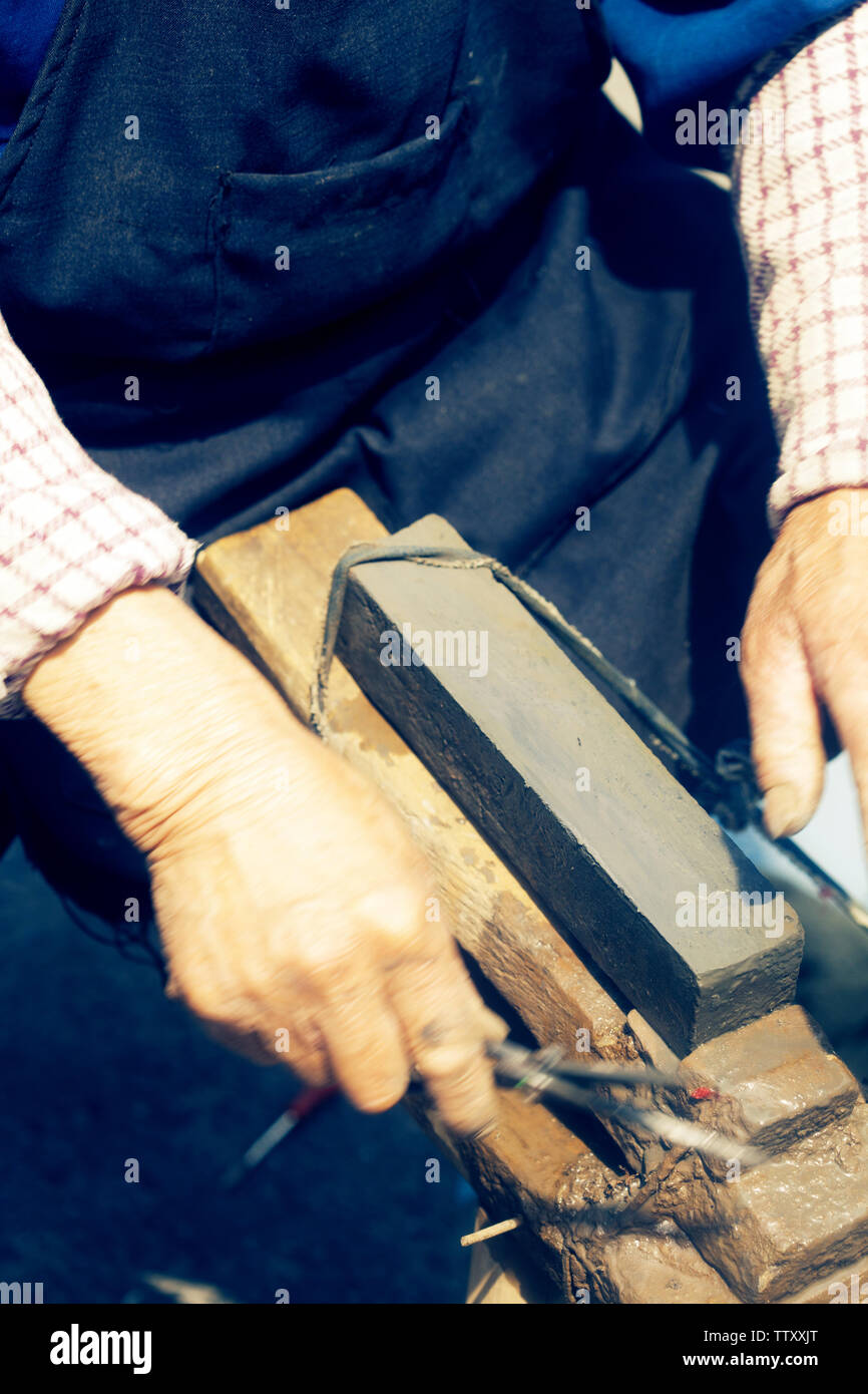 craftsman sharpen scissor with whetstone Stock Photo Alamy