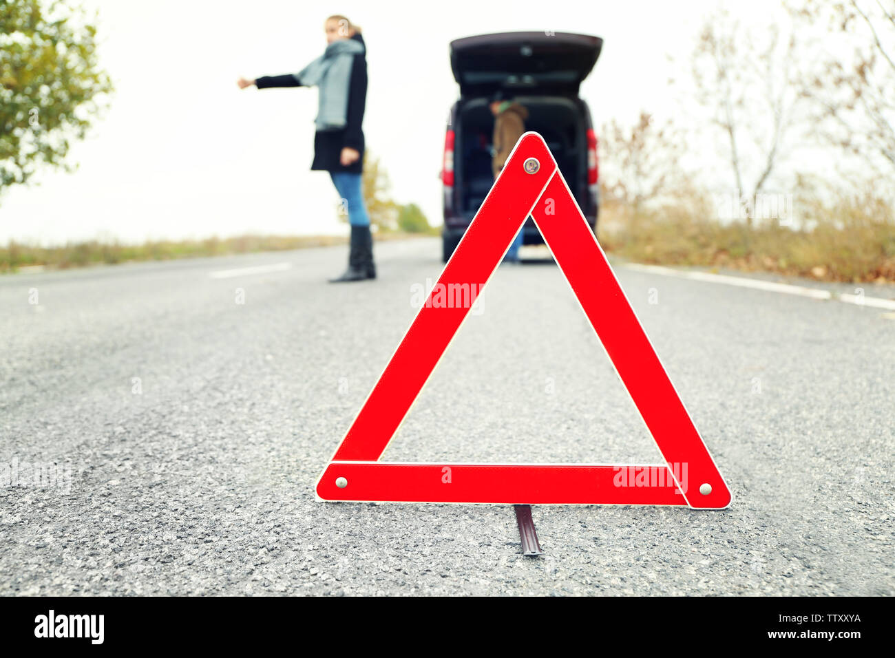 Traffic warning sign on road with car and couple on background Stock ...