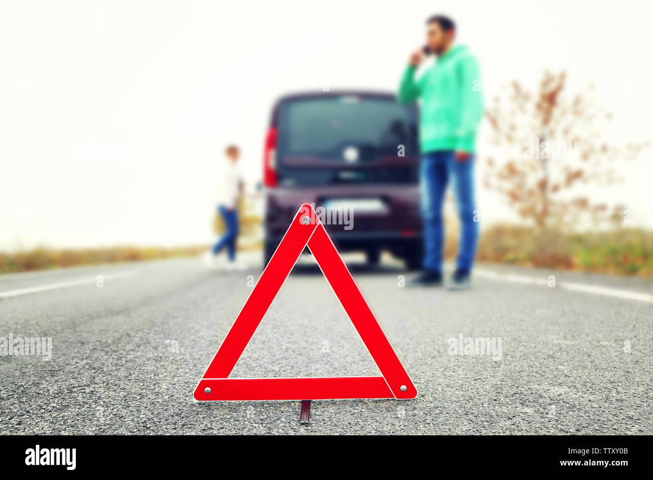 Traffic warning sign on road with car and couple on background Stock ...