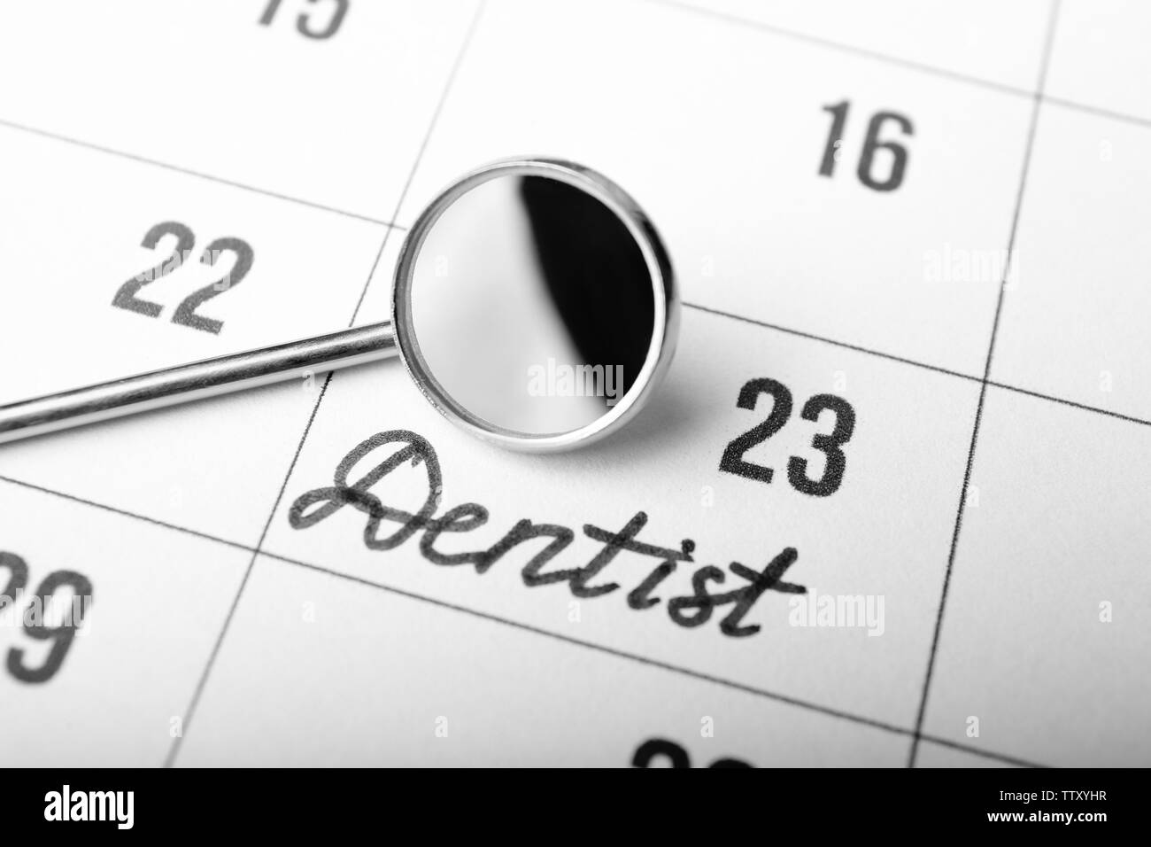 Dental mirror on calendar background Stock Photo