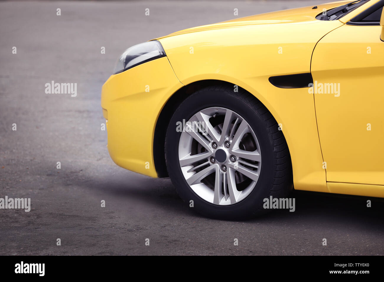 Wheel of yellow car on road, closeup Stock Photo - Alamy