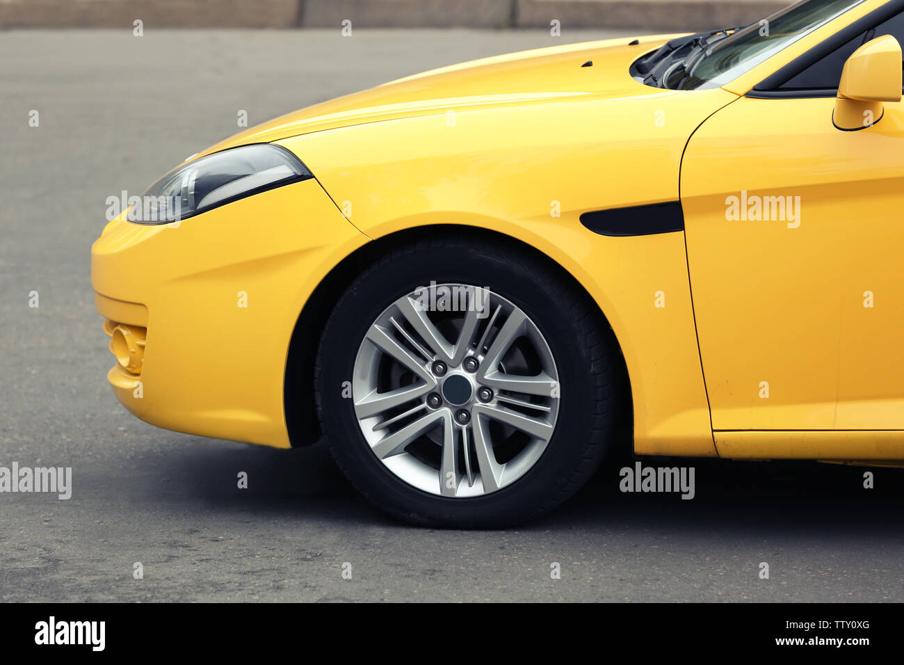 Wheel of yellow car on road, closeup Stock Photo - Alamy