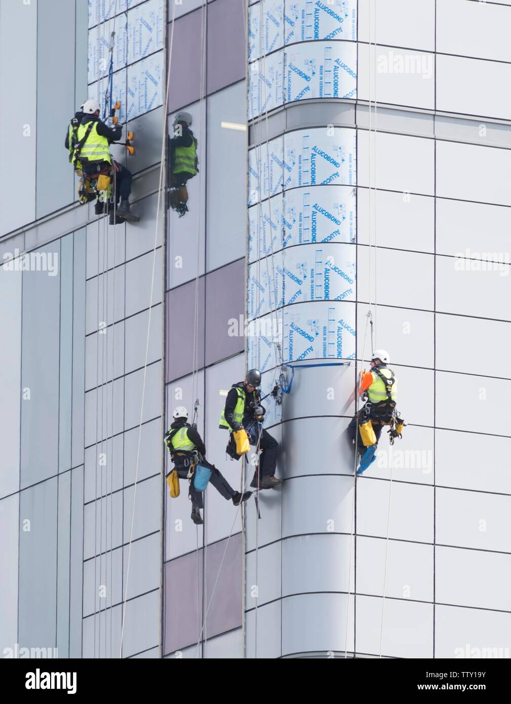 Workers use abseiling equipment to replace exterior unsafe cladding similar to that used in Grenfel Tower on the Queen Elizabeth Hospital in Glasgow. Stock Photo
