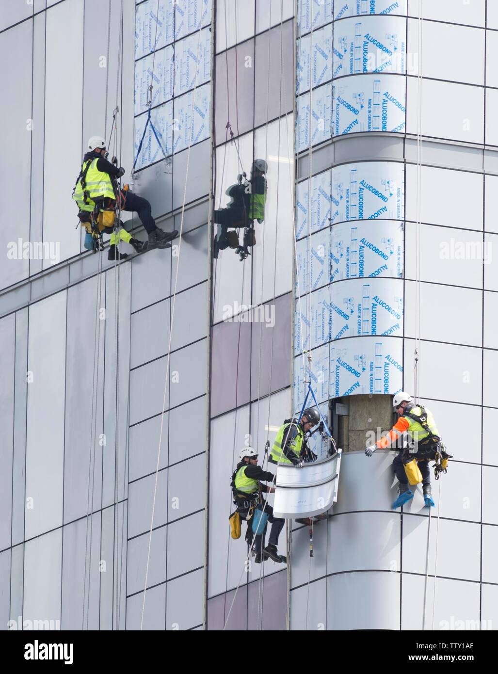 Workers use abseiling equipment to replace exterior unsafe cladding similar to that used in Grenfel Tower on the Queen Elizabeth Hospital in Glasgow. Stock Photo