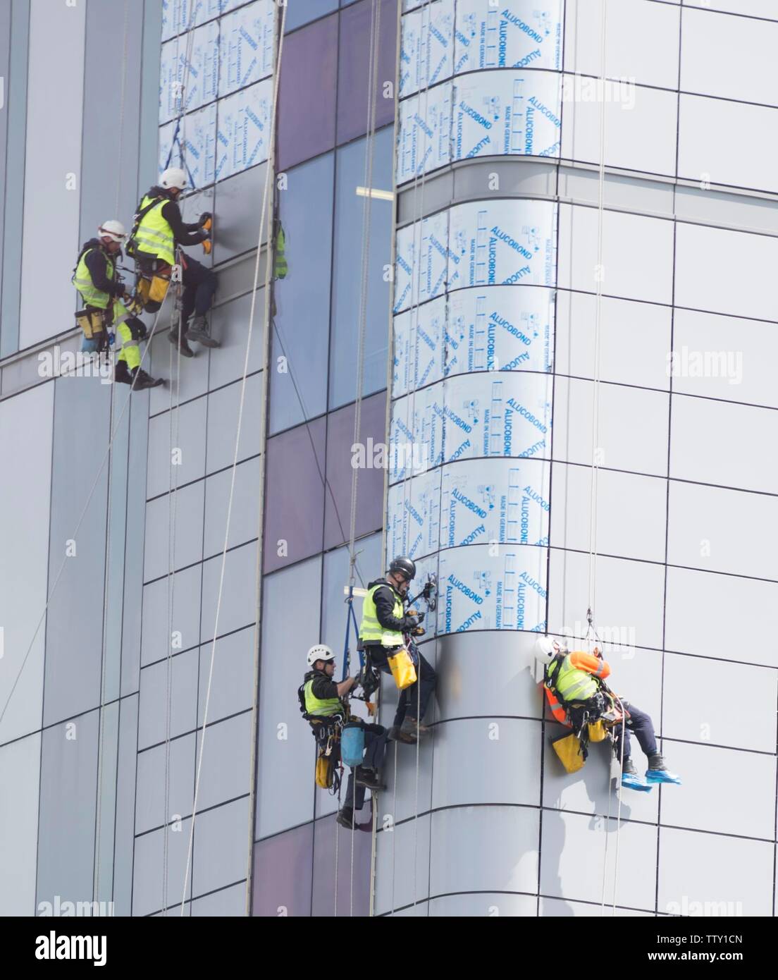 Workers Use Abseiling Equipment To Replace Exterior Unsafe