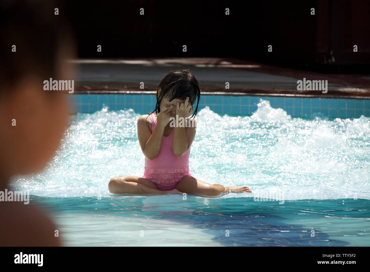 Girl playing in a swimming pool Stock Photo