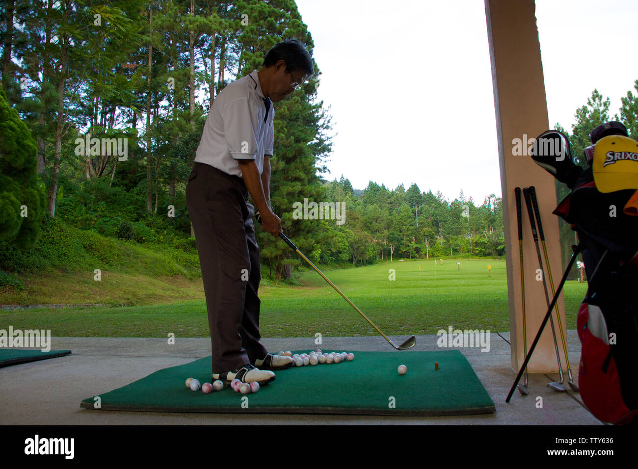 Man practicing golf at driving range Stock Photo
