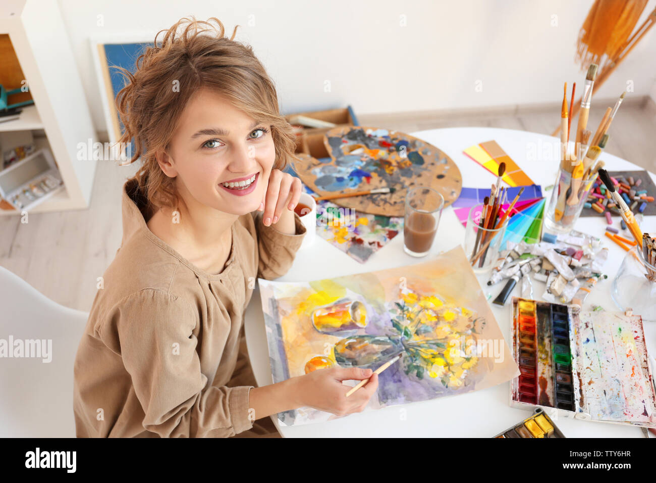 Young female artist painting picture in studio Stock Photo - Alamy