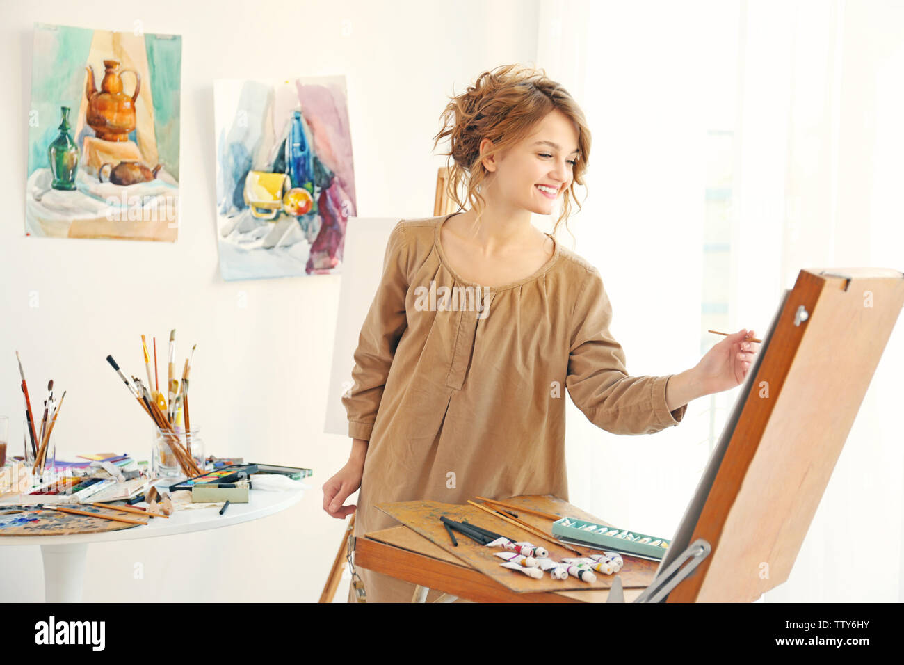 Young female artist painting picture in studio Stock Photo - Alamy