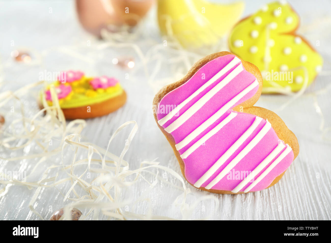 Creative rabbit shape Easter cookie and decorations on wooden table, closeup Stock Photo