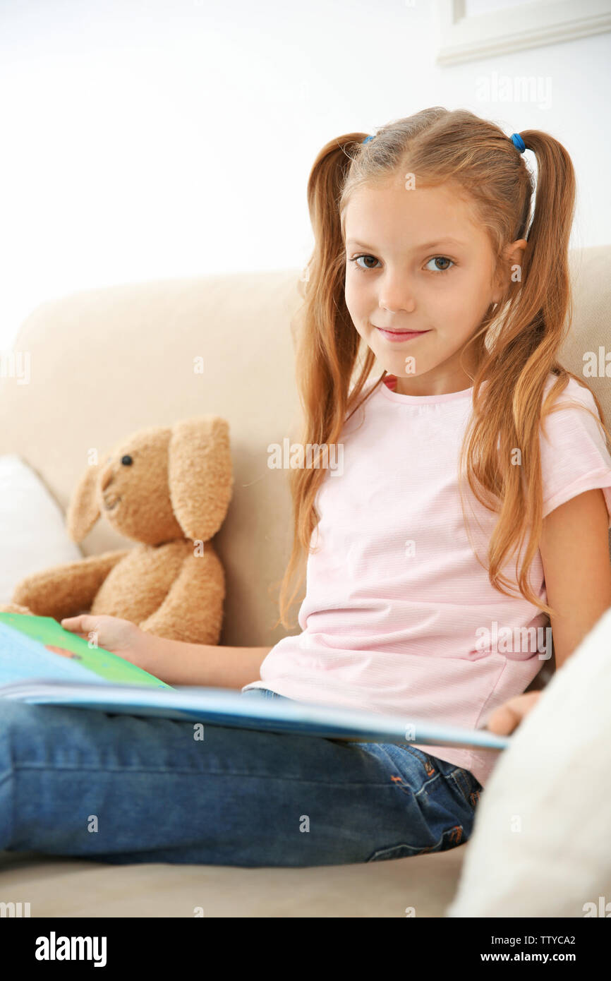 Cute girl with book at home Stock Photo - Alamy